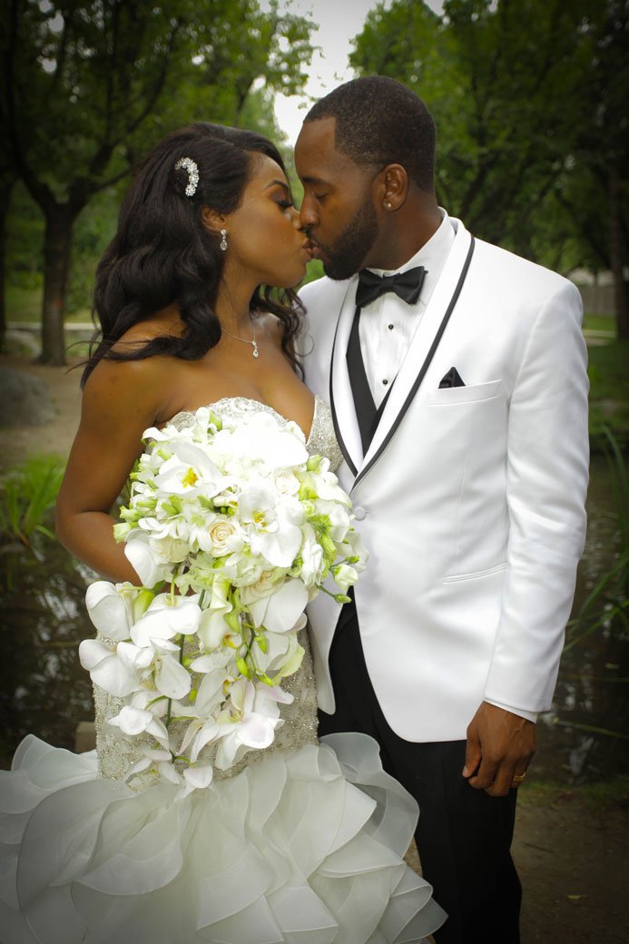 couple-kissing-in-the-park-on-their-wedding-day